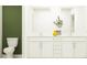 Double vanity bathroom with white cabinets and a green accent wall at 3740 Capital Reserve Dr, Plant City, FL 33565