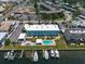 Aerial view of building, pool, boat slips, and marina at 423 S Paula Dr # 203, Dunedin, FL 34698