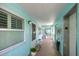 Condo hallway with elevator access and light teal walls at 423 S Paula Dr # 203, Dunedin, FL 34698