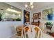 Bright dining area featuring a wood table, white chairs, and kitchen views at 4900 Brittany S Dr # 608, St Petersburg, FL 33715