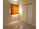 A sunlit bedroom with a window and a closet, featuring tiled floors at 5209 10Th S Ave, Gulfport, FL 33707