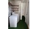 Laundry room with stacked washer and dryer, shelving and a green floor at 5209 10Th S Ave, Gulfport, FL 33707