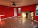 Living room featuring red walls, tiled floors, a brick fireplace, and ceiling fan at 5209 10Th S Ave, Gulfport, FL 33707