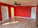 Living room with red walls, tiled floors, a fireplace and ceiling fan at 5209 10Th S Ave, Gulfport, FL 33707