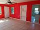 Spacious living room features a bright red accent wall, tile flooring, and natural light at 5209 10Th S Ave, Gulfport, FL 33707