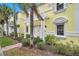 Exterior of light yellow building with walkway, lush landscaping, and pergola at 5258 Beach Se Dr, St Petersburg, FL 33705