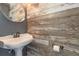 Charming powder room with pedestal sink and rustic wood-look wall tiles at 5366 Hader Rd, North Port, FL 34288