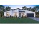 Modern house exterior with white walls, dark garage door, and landscaping at 6708 Burlington Ave, St Petersburg, FL 33710