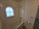 Bathroom with tub and shower, and arched window at 7041 Spotted Deer Pl, Riverview, FL 33569