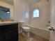 Bathroom with tub, toilet, and dark vanity at 7041 Spotted Deer Pl, Riverview, FL 33569