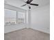 Well-lit room with neutral carpet, ceiling fan, and bright natural light at 7041 Spotted Deer Pl, Riverview, FL 33569