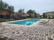 Community pool with lounge chairs and brick pavers at 7041 Spotted Deer Pl, Riverview, FL 33569