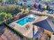 Aerial view of a sparkling community pool, lounge area, and lush landscaping at 7041 Spotted Deer Pl, Riverview, FL 33569