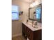 Bathroom with dark vanity, a large mirror and beige tile floors at 7097 Aberfeldy N Ave, St Petersburg, FL 33709