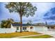 Newly renovated house with a white exterior, landscaped lawn, and attached garage at 7097 Aberfeldy N Ave, St Petersburg, FL 33709