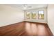 Bright bedroom featuring hardwood floors and multiple windows at 7119 Peregrina Loop, Wesley Chapel, FL 33545