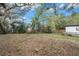 Large backyard with mature trees and a partially fenced perimeter at 7401 Mount Vernon Rd, Tampa, FL 33625