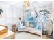 Bedroom with crib, ocean-themed wall mural, and plenty of storage at 7601 9Th N Ave, St Petersburg, FL 33710