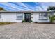 Stylish front entrance with black door and stone pavers at 7601 9Th N Ave, St Petersburg, FL 33710