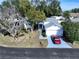 Aerial shot of a home highlighting its well-maintained lawn, mature trees, and inviting curb appeal in a quiet neighborhood at 7923 Leighton Cir, New Port Richey, FL 34654