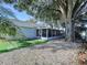 A screened lanai enhances this home's outdoor living space, nestled next to a lovely tree and gravel ground at 7923 Leighton Cir, New Port Richey, FL 34654