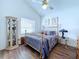 Cozy bedroom with wood floors, ceiling fan, and brass bed frame at 7923 Leighton Cir, New Port Richey, FL 34654