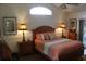 Main bedroom with wood furniture and an arched window at 7923 Leighton Cir, New Port Richey, FL 34654