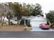 White house with gray roof, two-car garage, and red car parked in driveway at 7923 Leighton Cir, New Port Richey, FL 34654