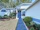 Close-up view of the home's entrance with blue door, landscaping, and architectural details at 7923 Leighton Cir, New Port Richey, FL 34654