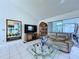 Living room with tile floors, vaulted ceiling with fan and sliding doors to the pool at 7923 Leighton Cir, New Port Richey, FL 34654