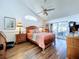 Bright main bedroom with a ceiling fan, hardwood floors, and large windows at 7923 Leighton Cir, New Port Richey, FL 34654