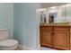 Small bathroom with granite countertop and wood cabinets at 820 Date Palm Ln, St Petersburg, FL 33707