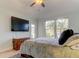 Bright bedroom with large TV, door to patio, and comfortable bed at 820 Date Palm Ln, St Petersburg, FL 33707