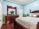 Bedroom with a wooden bed frame and dresser in a light blue and green room at 9516 Cypress Harbor Dr, Gibsonton, FL 33534