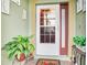 White front door with a storm door and decorative plants at 9516 Cypress Harbor Dr, Gibsonton, FL 33534