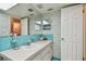 Bathroom with teal tile, vanity, and mirror at 11200 102Nd Ave # 138, Seminole, FL 33778