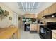 View of kitchen with wood cabinets, black appliances, and dining area at 124 W Cypress Ct, Oldsmar, FL 34677