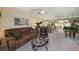 Living room with brown leather sofa, armchair, and glass coffee table at 124 W Cypress Ct, Oldsmar, FL 34677