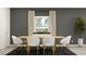 Modern dining room with a wood table, white chairs, and geometric rug at 12434 Sweet Angel Aura Way, Parrish, FL 34219