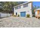 Detached garage with a blue door and paver driveway at 13833 Vacation Ln, Odessa, FL 33556