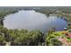 Stunning aerial view of a tranquil lake surrounded by lush greenery and homes at 13833 Vacation Ln, Odessa, FL 33556