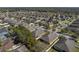 An aerial shot displaying a home with neat landscaping in a suburban community with many trees at 1525 Banner Elk St, Valrico, FL 33594