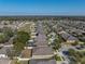 An aerial view shows a home with a pool in a neighborhood with trees and houses at 1525 Banner Elk St, Valrico, FL 33594