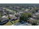 An aerial view of a home in a residential area featuring well-manicured lawns, mature trees, and a white fence at 1525 Banner Elk St, Valrico, FL 33594