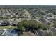 Aerial view of a property in a residential area, featuring green lawns and mature trees at 1525 Banner Elk St, Valrico, FL 33594