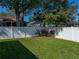 Well-maintained backyard featuring healthy green grass, a white fence, and decorative plants at 1525 Banner Elk St, Valrico, FL 33594