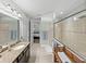 Bathroom featuring tiled walk-in shower with glass door, and granite countertop vanity at 1525 Banner Elk St, Valrico, FL 33594