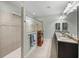 Bathroom featuring double vanity, large mirrors, tiled walk-in shower and neutral tones at 1525 Banner Elk St, Valrico, FL 33594