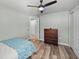 Bedroom boasts wood floors, ceiling fan and a wooden dresser at 1525 Banner Elk St, Valrico, FL 33594