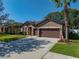 Charming single-story home with a beautiful lawn, landscaped garden beds, and a two-car garage at 1525 Banner Elk St, Valrico, FL 33594